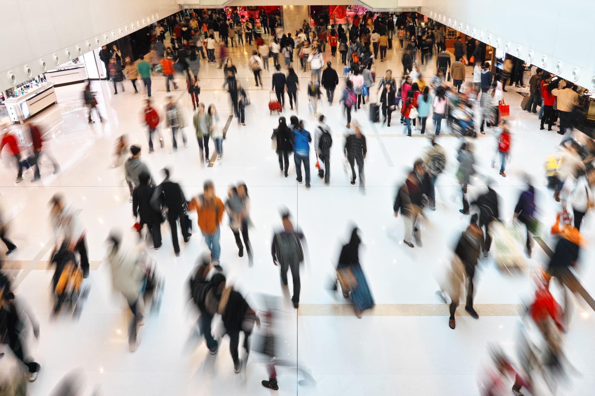 A large amount of people walking around an airport terminal