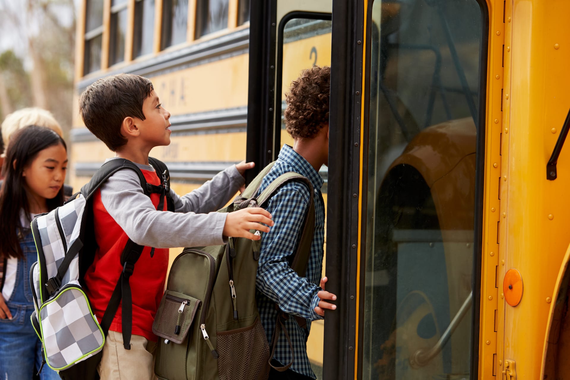 Grade school kids getting on the bus.