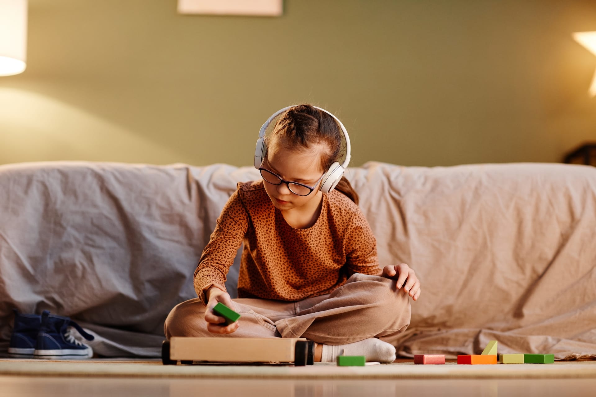 A young girl working on school work wearing noise suppression head phones.