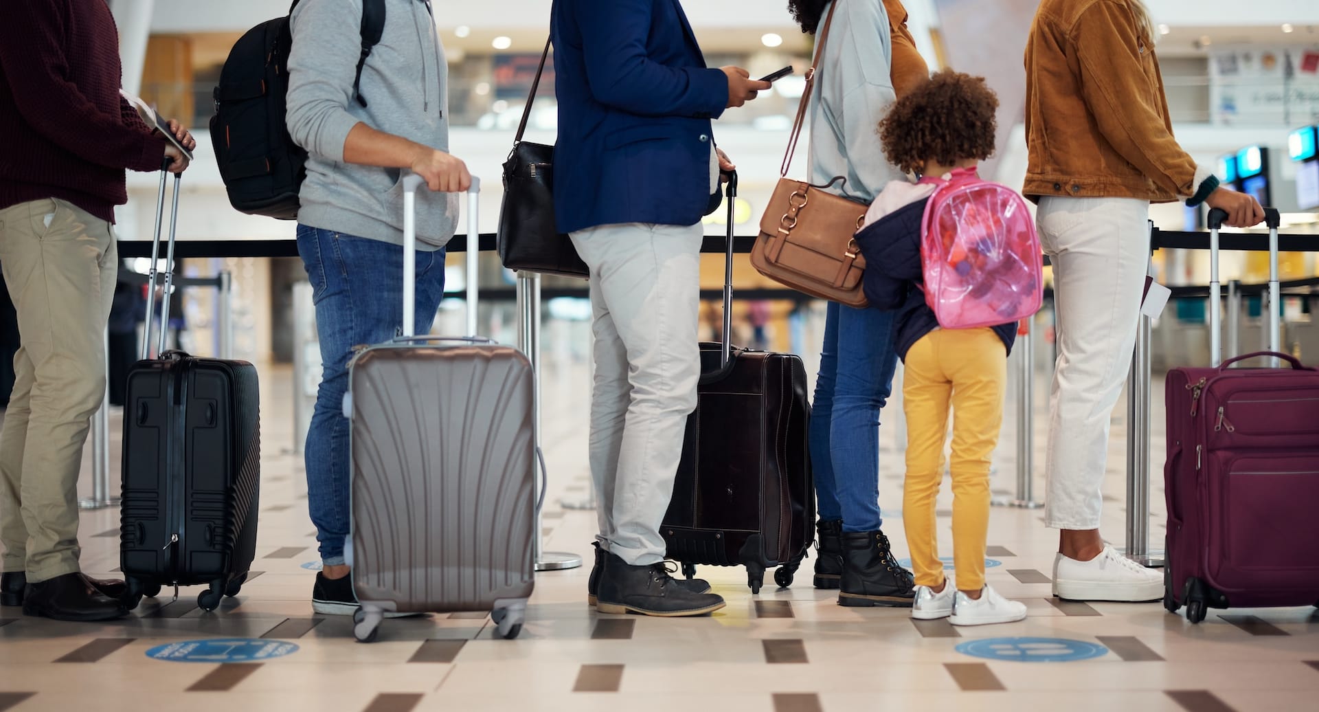 People standing in line to check in their luggage at the airport